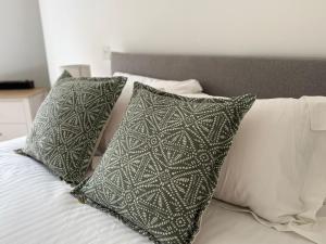a bed with three pillows on it with at The Loft at 2 Bath Street in Bath
