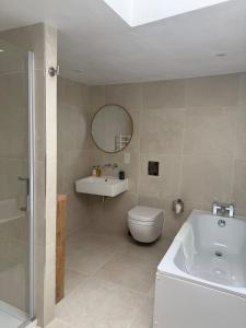 a bathroom with a tub and a toilet and a sink at The Loft at 2 Bath Street in Bath