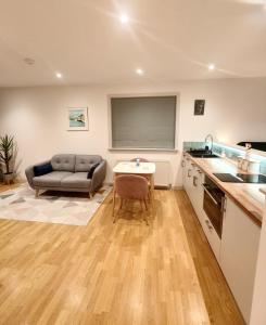 a kitchen and living room with a couch and a table at Hillside Park Studio in Easter Quarff