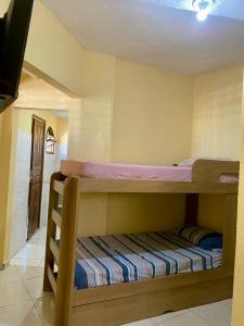 a bedroom with two bunk beds in a room at Kitnet confortável no centro de cabo frio in Cabo Frio