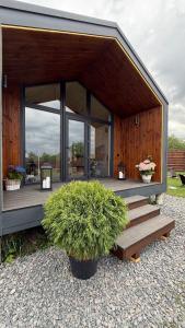 a small house with a porch and a potted plant at ForRest будинок з чаном in Moshchun +13 photos