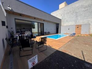 a house with a deck with a swimming pool at Edícula para descansar e passar ótimos momentos in Foz do Iguaçu