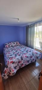 a bedroom with a bed with a quilt on it at cabaña elquimilen in Vicuña +15 photos