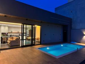 a swimming pool in a house with a living room at Edícula para descansar e passar ótimos momentos in Foz do Iguaçu