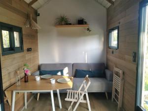 a tiny house with a table and a couch at Tinyhouse, winter cocoon, quiet and nature in Languidic
