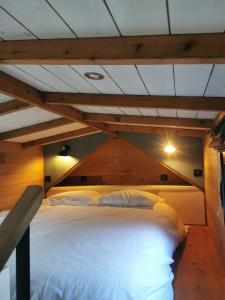 a large white bed in a room with a ceiling at Tinyhouse, winter cocoon, quiet and nature in Languidic +25 photos
