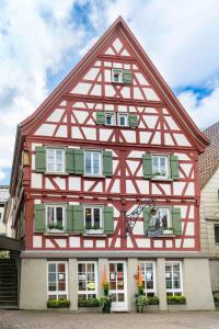 a half timbered house with red and white at Pension Pauserei in Oedheim