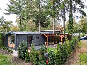a tiny house in the woods with a garden at Tiny House Forestia met HOTTUB in Hoenderloo