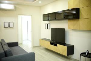 a living room with a couch and a flat screen tv at Parthenope Luxury Apartment in Naples