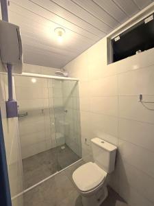 une salle de bain avec toilettes et douche en verre dans l'établissement Sea Wolf Surf Hostel Campeche, à Florianópolis