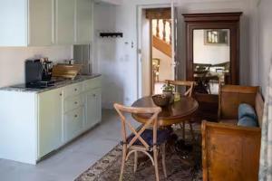 a kitchen with a table and a table and chairs at Château Studio With Water Views in Saint-Lubin-des-Joncherets