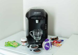 a black coffee maker sitting on a counter with candy at Duplex 2 min train station, Paris 15 min in Versailles