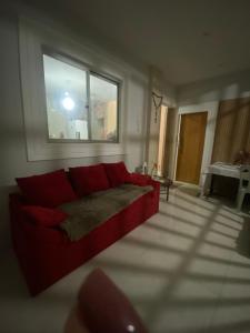 a red couch in a living room with a window at HospCOP in Belém