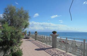 a walkway next to a fence with the ocean at A' Casitta Home in Furci Siculo