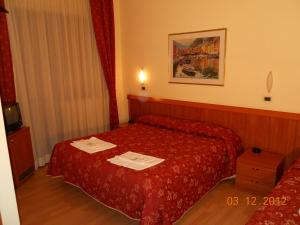 a hotel room with a red bed with towels on it at Hotel Val Di Sangro in Perano