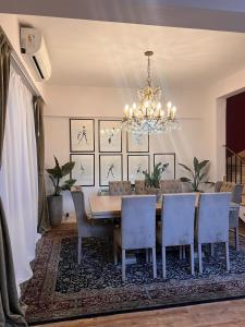 ein Esszimmer mit Tisch und Stühlen und einem Kronleuchter in der Unterkunft Recoleta Luxury Getaway Retreat Condo in Buenos Aires