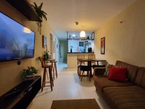 a living room with a couch and a dining room at Apartamento Dei Fiori in Guaramiranga