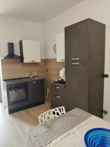 Il comprend une cuisine équipée d'un réfrigérateur noir et d'une table. dans l'établissement Casicarillo 800 appartamento moderno, à Serino