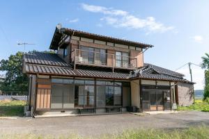 ein Gebäude mit einem Balkon darauf in der Unterkunft サウナ&ステイ吉日荘-益子町のサウナ付の貸切古民家 BBQ 高速Wi-fi in Mashiko