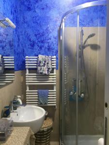 a blue bathroom with a sink and a shower at Happy Home Apartament in Arezzo