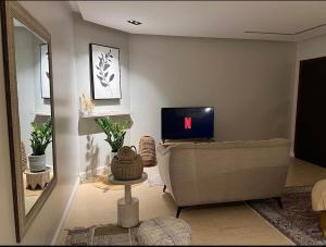 a living room with a couch and a tv at استديو النورس 4 - بطراز البوهيمي بـ دخول ذاتي in Dammam