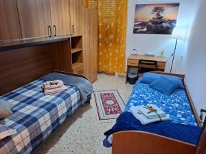 a bedroom with two beds and a desk in it at Magnolia Grande in Chieti