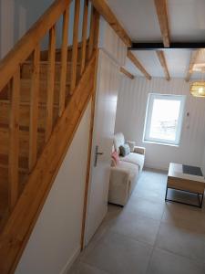 ein Wohnzimmer mit Treppe und Couch in der Unterkunft Appartement cosy et calme in Saint-Pierre-de-Boeuf
