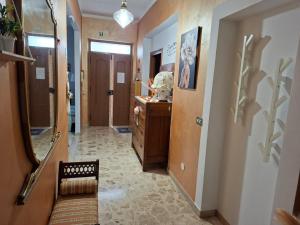 a hallway leading to a bathroom with a vanity and a mirror at Magnolia Grande in Chieti +3 photos