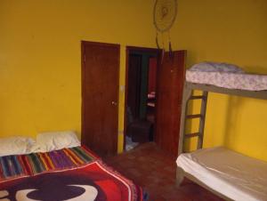 a bedroom with two bunk beds and a room with a ladder at Hostal El Encanto in La Ceiba