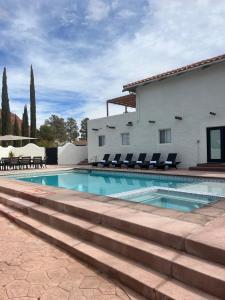 a swimming pool with lounge chairs and a house at Sierra Del Feugo apt # B in Ivins