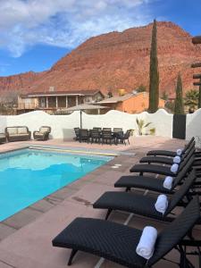 a group of lounge chairs next to a swimming pool at Sierra Del Feugo apt # B in Ivins