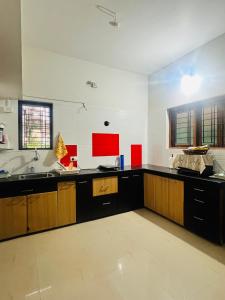 a large kitchen with black counters and a sink at Villa Sereno Belgaum in Belgaum