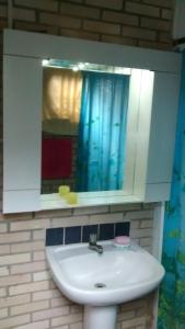 ein Badezimmer mit Waschbecken und Spiegel in der Unterkunft Pedra Escondida in Imbituba