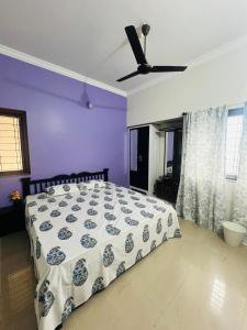 a bedroom with a bed and a ceiling fan at Villa Sereno Belgaum in Belgaum