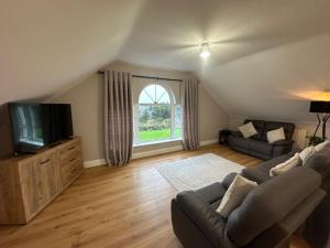 a living room with a couch and a tv at Conors view in Annagry