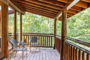 a porch with chairs and a table on it at Sereni-Tree Cabin in the Smokey Mountains in Sevierville
