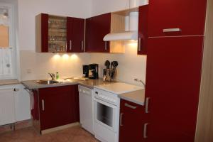 a kitchen with red cabinets and a sink at Apartment Horn in Pirna