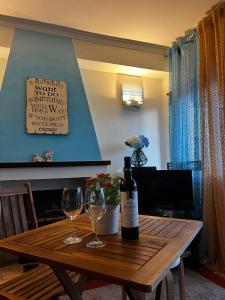 eine Flasche Wein und zwei Gläser auf einem Holztisch in der Unterkunft Casa da Areia Branca in Bolembre de Baixo