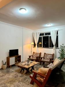 a living room with a table and chairs and a tv at Quarto na Av Beira mar em apto familiar in Fortaleza