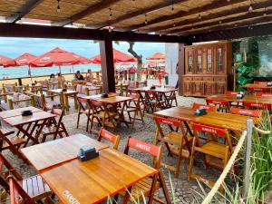 Elegância Praia da Sereia في فيلا فيلها: مطعم على الشاطئ به طاولات وكراسي