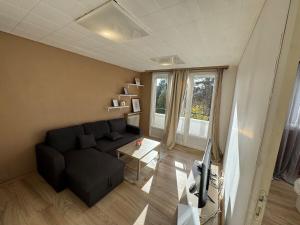 Una sala de estar con un sofá y un televisor. en Grand appartement lumineux, en Beauvais