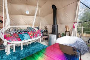 a swing bed with colorful pillows in a tent at Wonderland in Henfield
