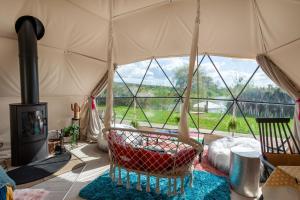 a room with a hammock in a tent with a fireplace at Wonderland in Henfield