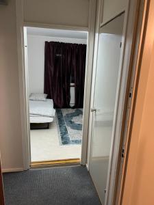 a room with a door leading to a bedroom with a bed at Stodio i stockholm in Märsta