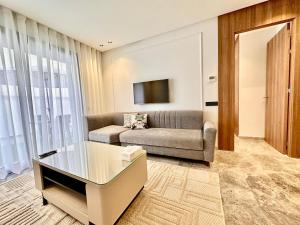 a living room with a couch and a tv at Spacious, Quiet Apartment with Parking , Fiber in Casablanca