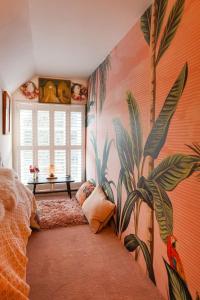 a bedroom with a mural of plants on the wall at Artists Hideaway in Cowfold