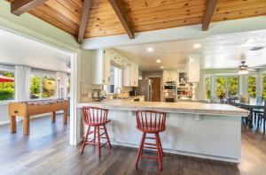 a kitchen with two red bar stools and a table at Starry Pines- Hot Tub in Yosemite Forks