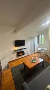 a living room with a coffee table and a fireplace at Apartament Sol i Vent La Molina in La Molina