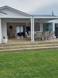 een terras met stoelen en een tafel bij Inner city Sanctuary in Gisborne +21 foto's