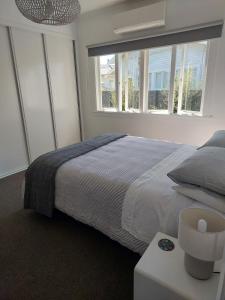 a bedroom with a large bed and two windows at Inner city Sanctuary in Gisborne +29 photos